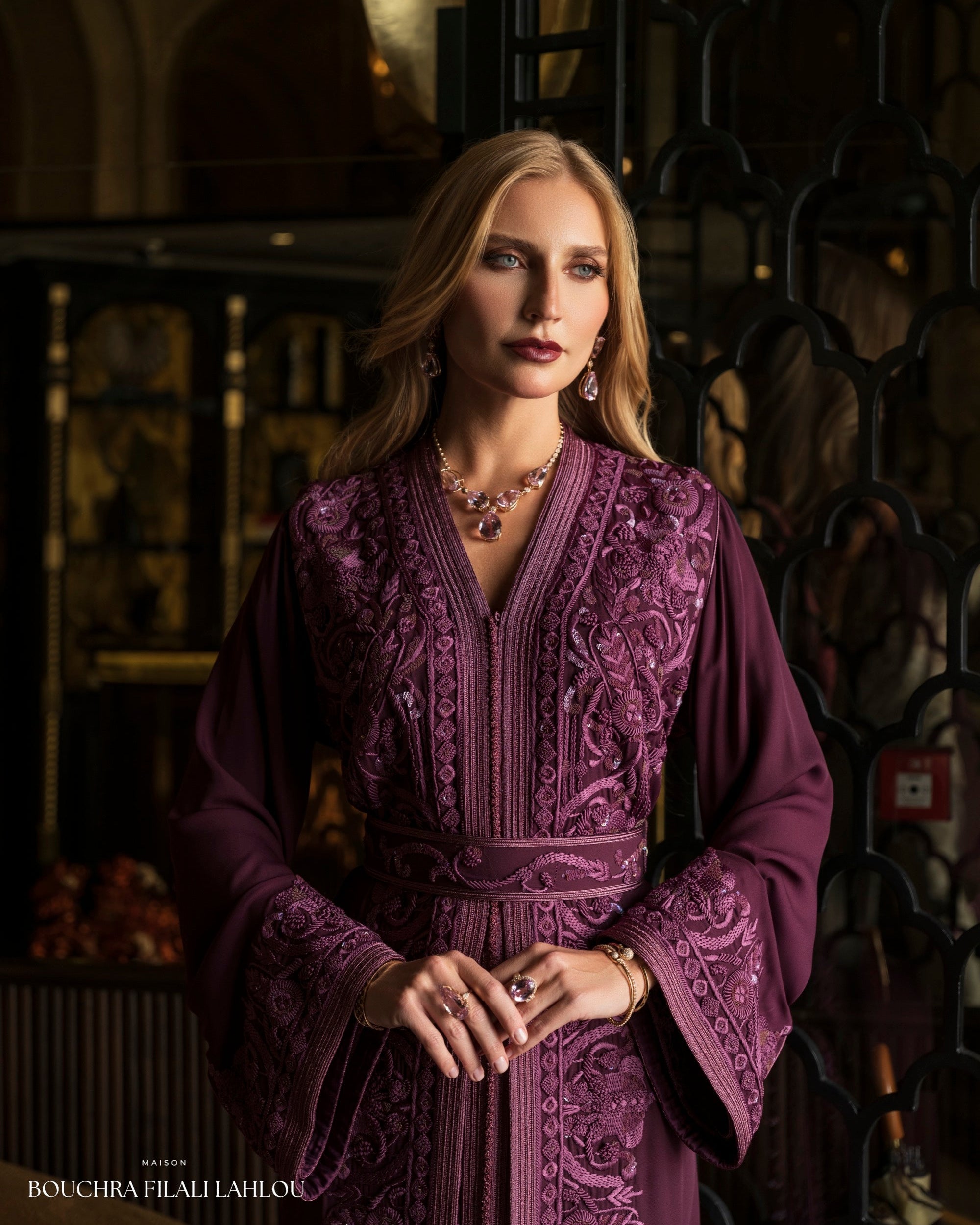 Deep violet Moroccan caftan detail with ornate embroidery and fluid wide sleeves