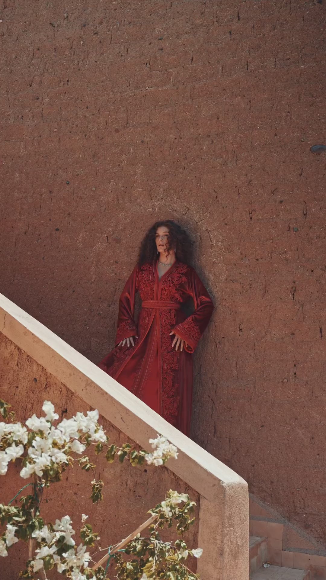 Garnet Adagio burgundy velvet Moroccan kaftan with tone-on-tone embroidery, matching belt and wide sleeves, in motion